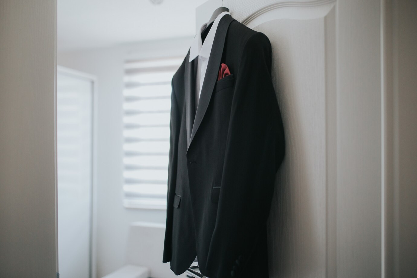 black-suit-white-shirt-is-hanging-from-hanger-from-door_181624-9326 چوب لباسی مخصوص کت و شلوار