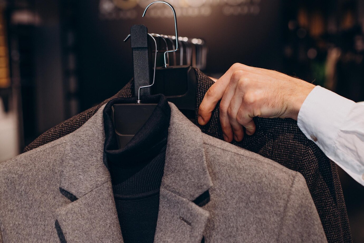 young-man-choosing-cloths-menswear-shop_1303-30951 چوب لباسی مخصوص کت و شلوار
